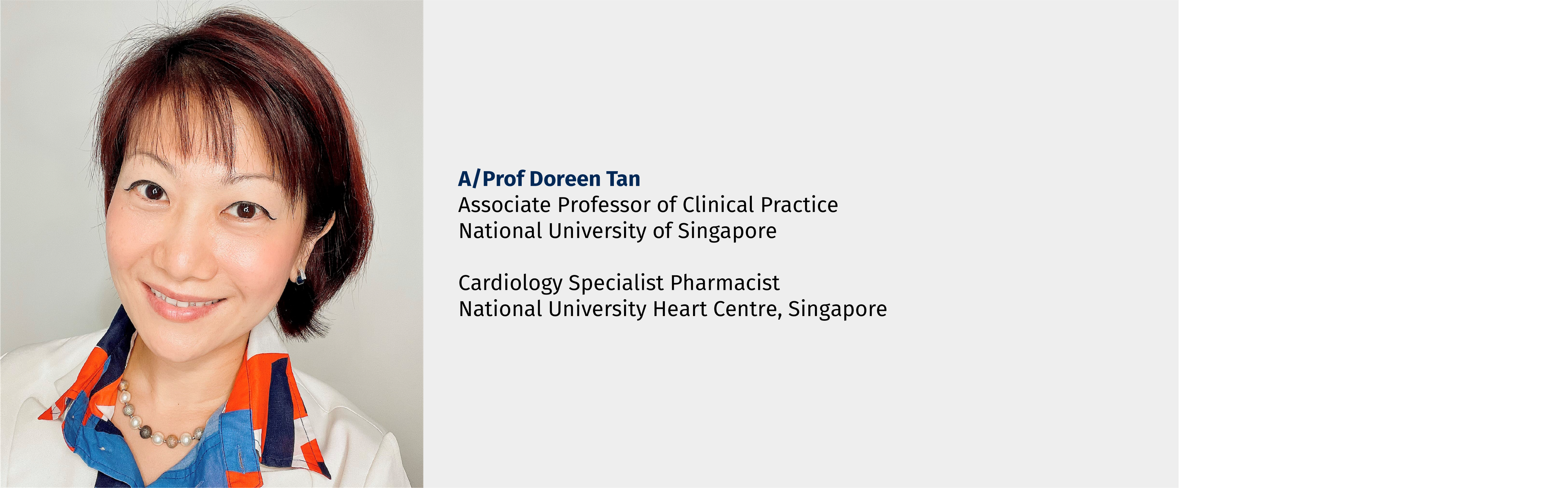 A/Prof Doreen Tan, smiling woman with short dark red hair, wearing a colorful top and pearl necklace.